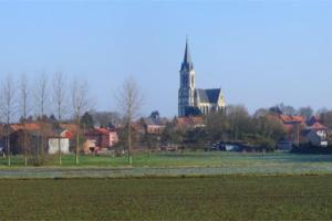 a field with houses and a building in the background at studio relais Philippe Auguste in Bouvines