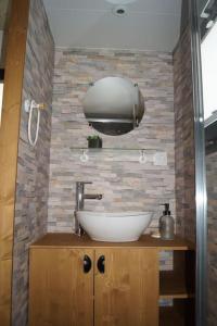 a bathroom with a bowl sink and a brick wall at SPA & Tiny house à la campagne in La Boissière +6 photos