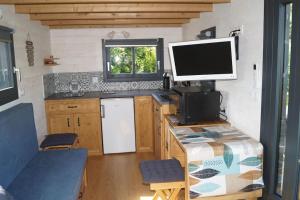 a kitchen with a desk with a computer monitor on it at SPA & Tiny house à la campagne in La Boissière