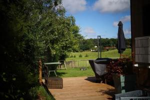 a patio with an umbrella and a table and a chair at SPA & Tiny house à la campagne in La Boissière