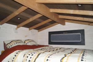 a bedroom with a large bed with a window at SPA & Tiny house à la campagne in La Boissière