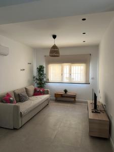 Una sala de estar con un sofá y un televisor. en Indalo Mar Menor - Cozy modern stay in Old Town near the beach, en Los Alcázares