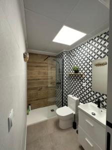 Un baño con inodoro, ducha y lavabo. en Indalo Mar Menor - Cozy modern stay in Old Town near the beach, en Los Alcázares 44 fotos más