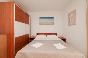 een slaapkamer met een bed met twee handdoeken erop bij Apartment Marta in Maslenica