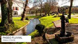 a park with a bench next to a river at Apartamento Pose Arteixo in Arteixo