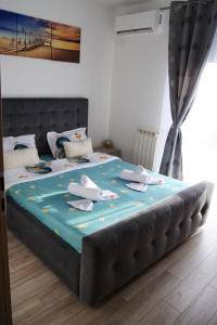 a large bed with a blue blanket on top of it at Apartament Panorama Baile Felix in Baile Felix