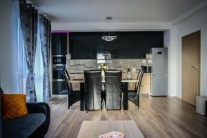 a kitchen and living room with a table and a dining room at Apartament Panorama Baile Felix in Baile Felix