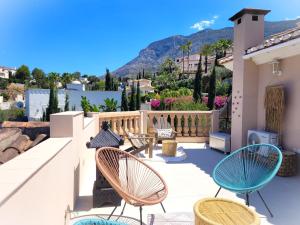 een patio met stoelen en tafels op een huis bij Villa Flor de Neu in Denia