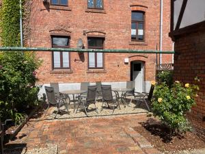 a patio with a table and chairs in front of a brick building at Fewo Rico 3 in Quedlinburg +7 photos