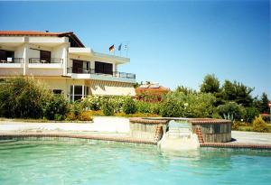 a swimming pool in front of a house at Hotel Pashos in Kriopigi