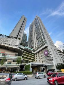 deux grands immeubles avec des voitures garées dans un parking dans l'établissement The Robertson Residence in bukit bintang, à Kuala Lumpur