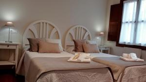 a bedroom with two beds with towels on them at Apartamentos La Blanca in Nueva de Llanes