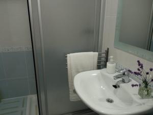 a white bathroom with a sink and a mirror at Apartamentos La Blanca in Nueva de Llanes +46 photos