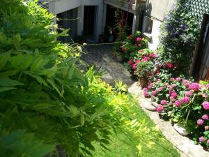 a garden with flowers and plants in front of a building at Le Clos Saint Nizier in Troyes