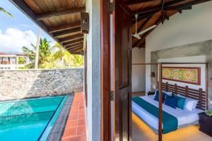 a bedroom with a bed next to a swimming pool at Anama by Queens Mount in Tangalle