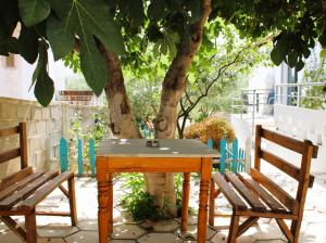 una mesa de madera y dos sillas junto a un árbol en Vila Rafael Ksamil, en Ksamil