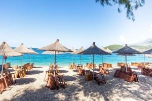 a beach with chairs and umbrellas on the sand at Potam'Sea Bliss 6 - Beach Front, Sun Beds & Parking in Himare