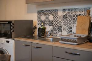 a kitchen counter with a sink and a microwave at Fisherman's House Cozy Duplex in Argenton-sur-Creuse