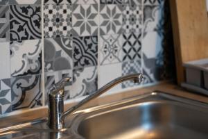 a sink with a faucet in a kitchen with tiles at Fisherman's House Cozy Duplex in Argenton-sur-Creuse