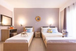 a bedroom with two beds and a chair in it at Potam'Sea Bliss 6 - Beach Front, Sun Beds & Parking in Himare