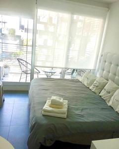 a bedroom with a large bed with two towels on it at Dolce Apartment in Buenos Aires