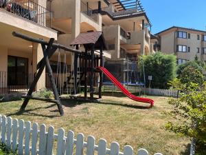 a playground with a red slide in front of a building at Kaliakria Vibes studio apartment in Topola