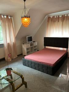 a bedroom with a bed and a table and a chandelier at Apartment im Düsseldorfer Norden in Düsseldorf