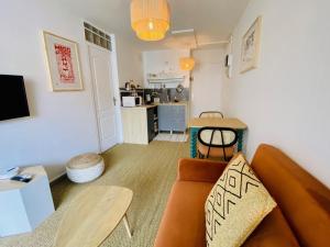 a living room with a couch and a table at Superbe T2 coté gare Parking Clim Wifi Terrasse ! in Sète +15 photos