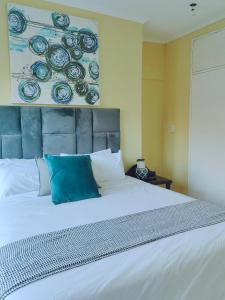 センチュリオンにあるChoosers Express Boutique Hotel Room 5の大きな白いベッドと青い枕のある寝室