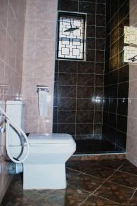 a bathroom with a white toilet and a shower at Lulufurnishedapartments in Mombasa
