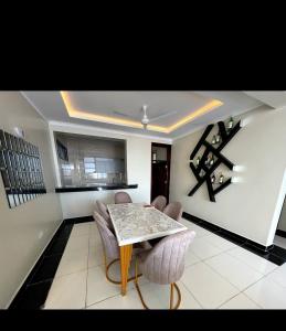 a living room with a table and chairs and a kitchen at Lulufurnishedapartments in Mombasa