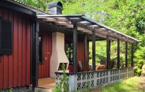 a pergola over a deck on a red house at Holiday Home Putsered Knäred in Putsered