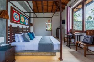 a bedroom with a bed and a table in a room at Anama by Queens Mount in Tangalle