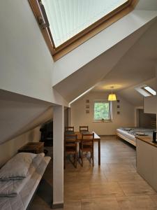 a room with a bed and a table and chairs at Apartamenty Ambra in Dębina