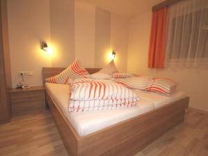 ナウダースにあるApart Carmenのベッドルーム1室(オレンジと白の枕が備わるベッド1台付)