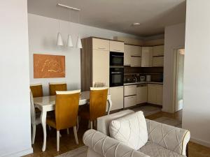 une cuisine et une salle à manger avec une table et des chaises dans l'établissement J&D Apartment Prishtina - 1 double & 2 single beds, à Pristina