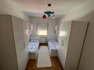une petite chambre avec deux lits et une fenêtre dans l'établissement J&D Apartment Prishtina - 1 double & 2 single beds, à Pristina