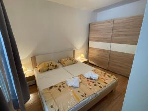 a small bedroom with a bed and a cabinet at Apartmani Roko in Ražanac