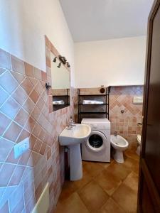 a bathroom with a sink and a washing machine at Villa Sunrise in Budoni