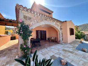 a courtyard of a house with an arch and flowers at Villa Sunrise in Budoni
