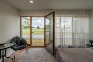 Un dormitorio con una cama y una mesa y una ventana. en KURŠIŲ VĖJAS apartamentai Svencelėje pirmame aukšte su terasa, en Svencelė
