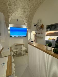 a kitchen with a counter with a tv on the wall at Acqua e Sale in Gallipoli +18 photos