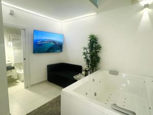 a bathroom with a tub and a tv on the wall at Acqua e Sale in Gallipoli