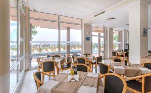a restaurant with tables and chairs and windows at Студия 310 и 312 на първа линия in Chernomorets