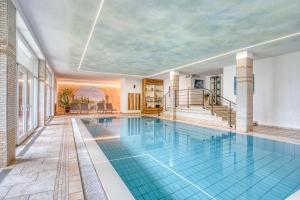 an indoor swimming pool with a ceiling at Das Bergland - Vital & Activity in San Leonardo in Passiria