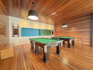 two ping pong tables in a room with wooden floors at Suíte Moderna com acesso ao Shopping in Brasilia