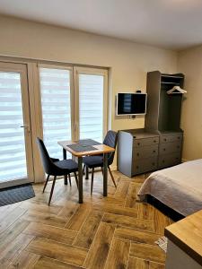 een hotelkamer met een tafel, stoelen en een bed bij Apartmens LORETA in Šventoji