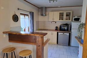 a kitchen with a counter and some stools in it at Lot et Garonne Gîte en campagne pour 6 personnes Piscine et jardin in Damazan