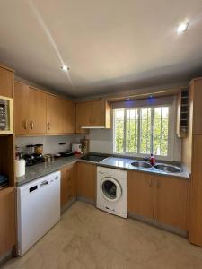 a kitchen with a sink and a washing machine at Marbella Beach House in Estepona