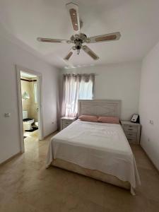 a bedroom with a bed and a ceiling fan at Marbella Beach House in Estepona